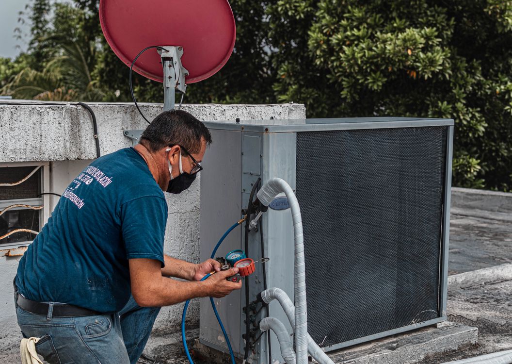 HVAC technician servicing an outdoor air conditioning unit